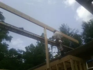 Carpenter setting a ridge beam over a new addition frame — Ice Dam Removal by Roofing Brothers in Elmhurst